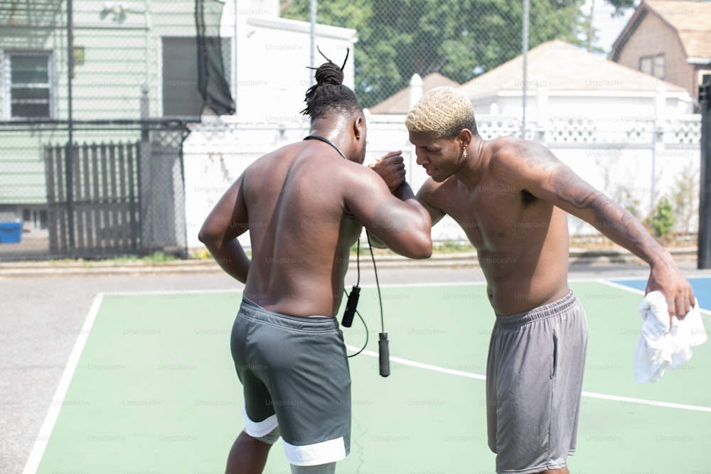 a couple of men standing on top of a tennis court