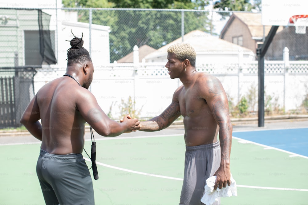 a couple of men standing on top of a tennis court