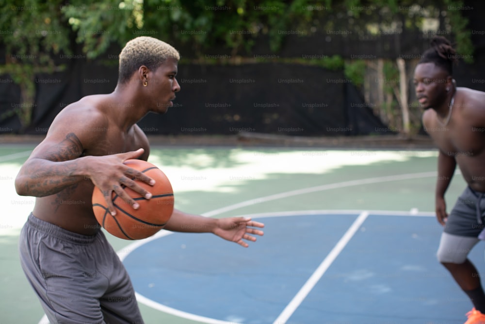 Un hombre sosteniendo una pelota de baloncesto en una cancha de baloncesto