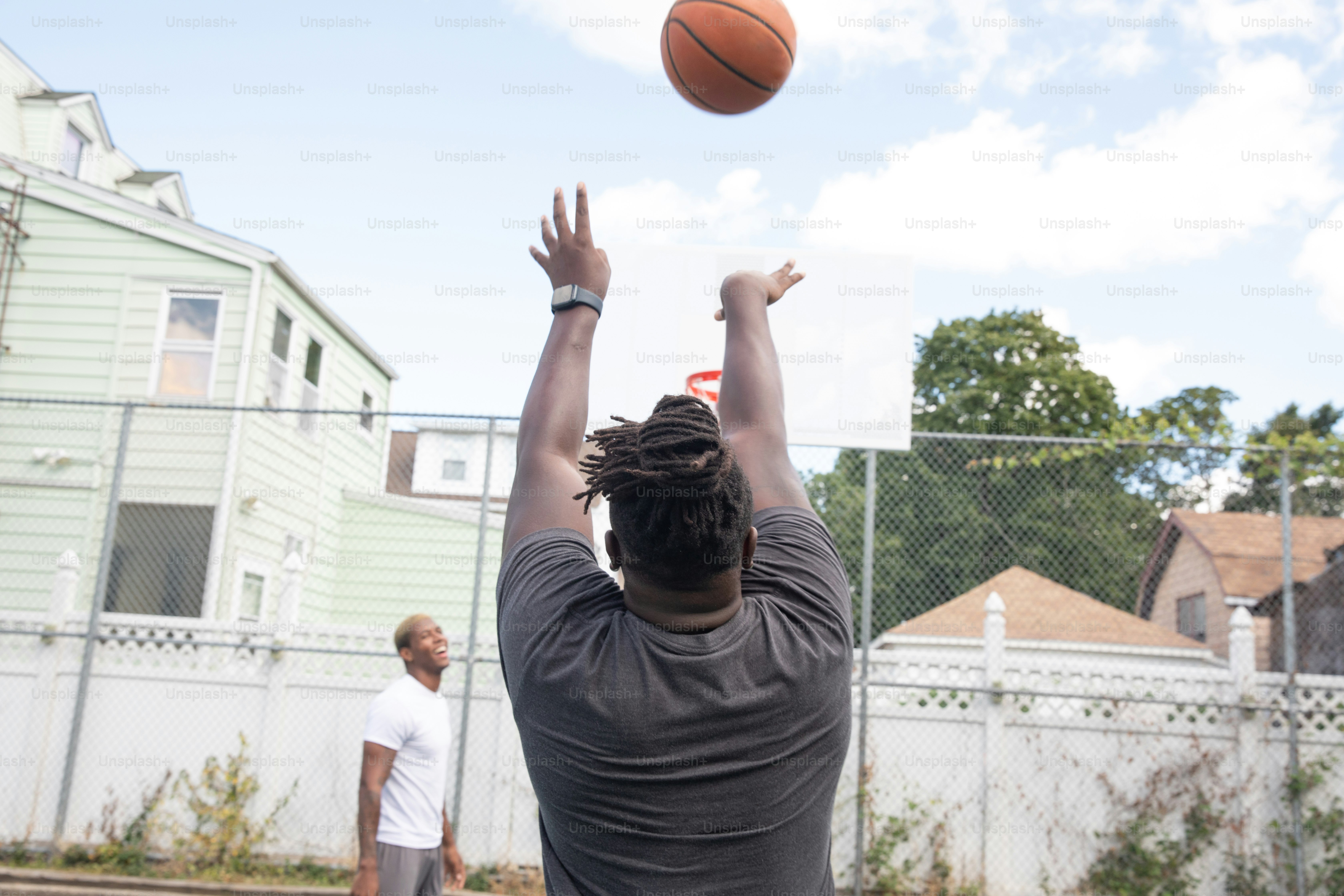a man reaching up to grab a basketball in the air