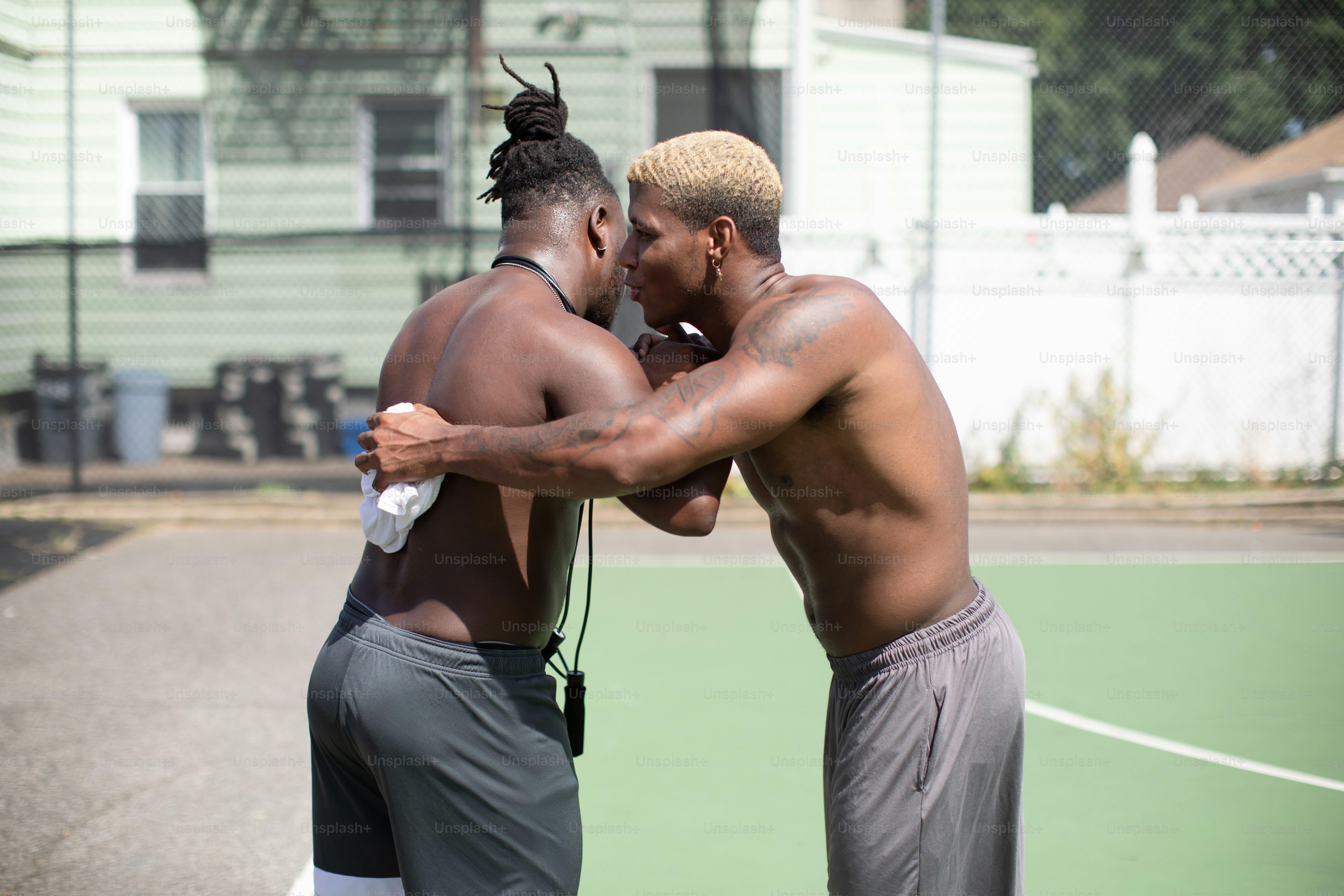 a couple of men standing on top of a tennis court