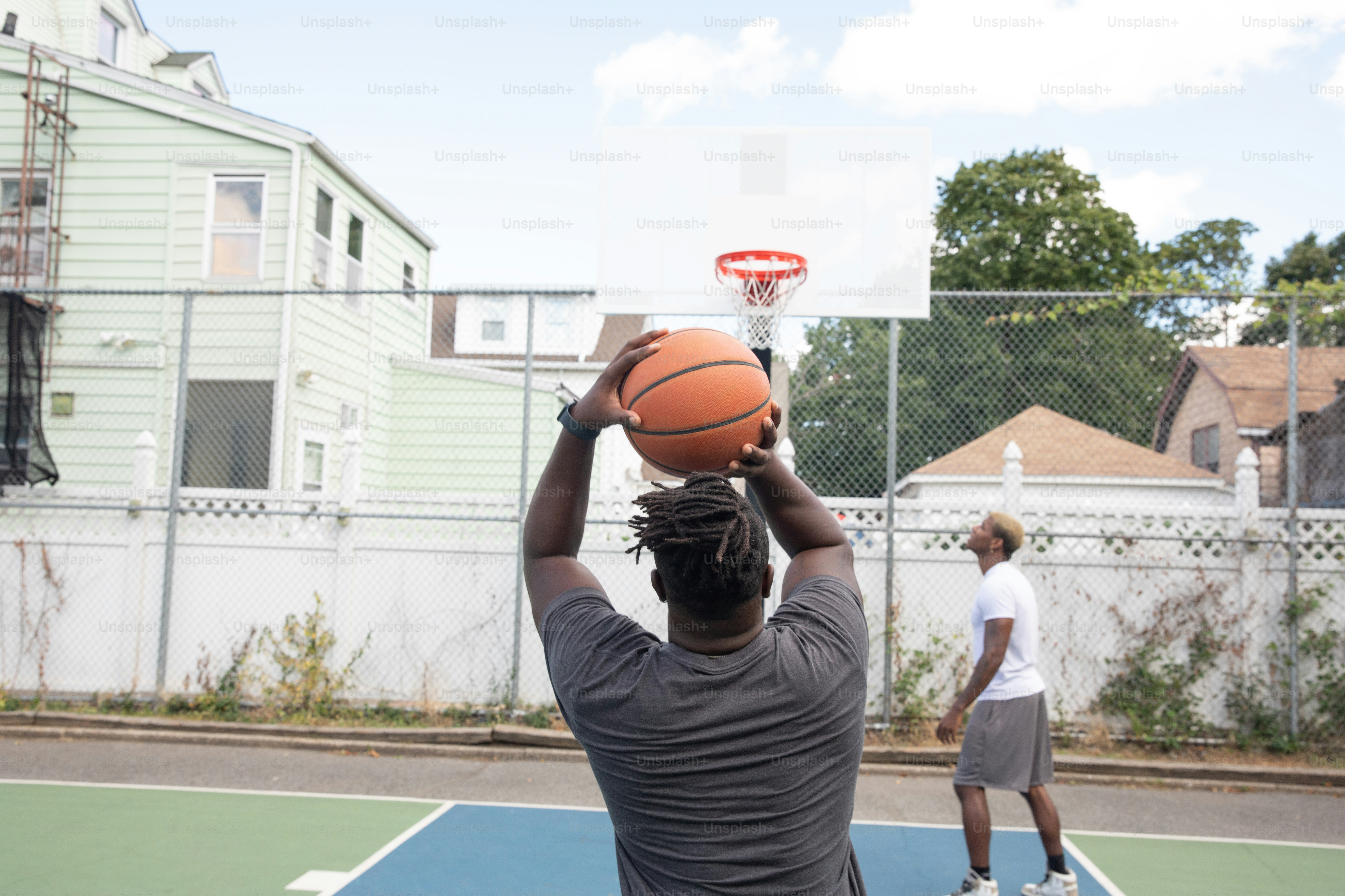 a man holding a basketball on top of a basketball court