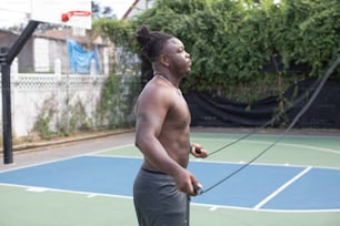 Un hombre parado en una cancha de tenis sosteniendo una raqueta de tenis