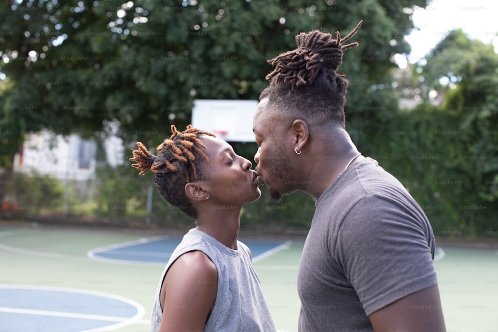 Ein Mann und eine Frau küssen sich auf einem Basketballplatz