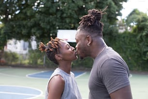 Un hombre y una mujer besándose en una cancha de baloncesto