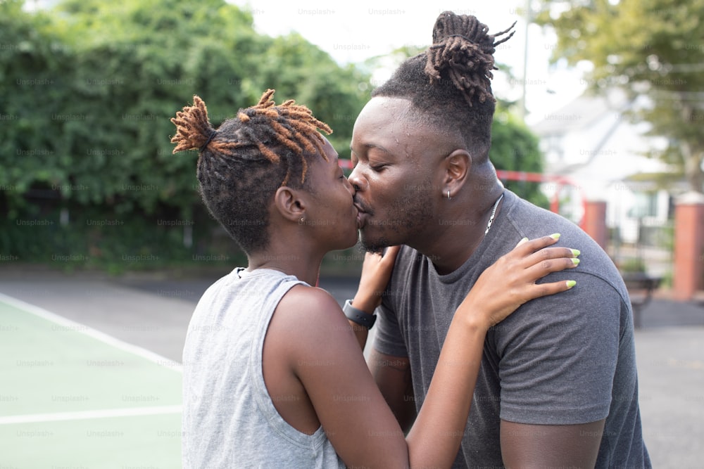 Un hombre y una mujer besándose en una cancha de tenis