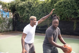 a couple of men standing on top of a tennis court