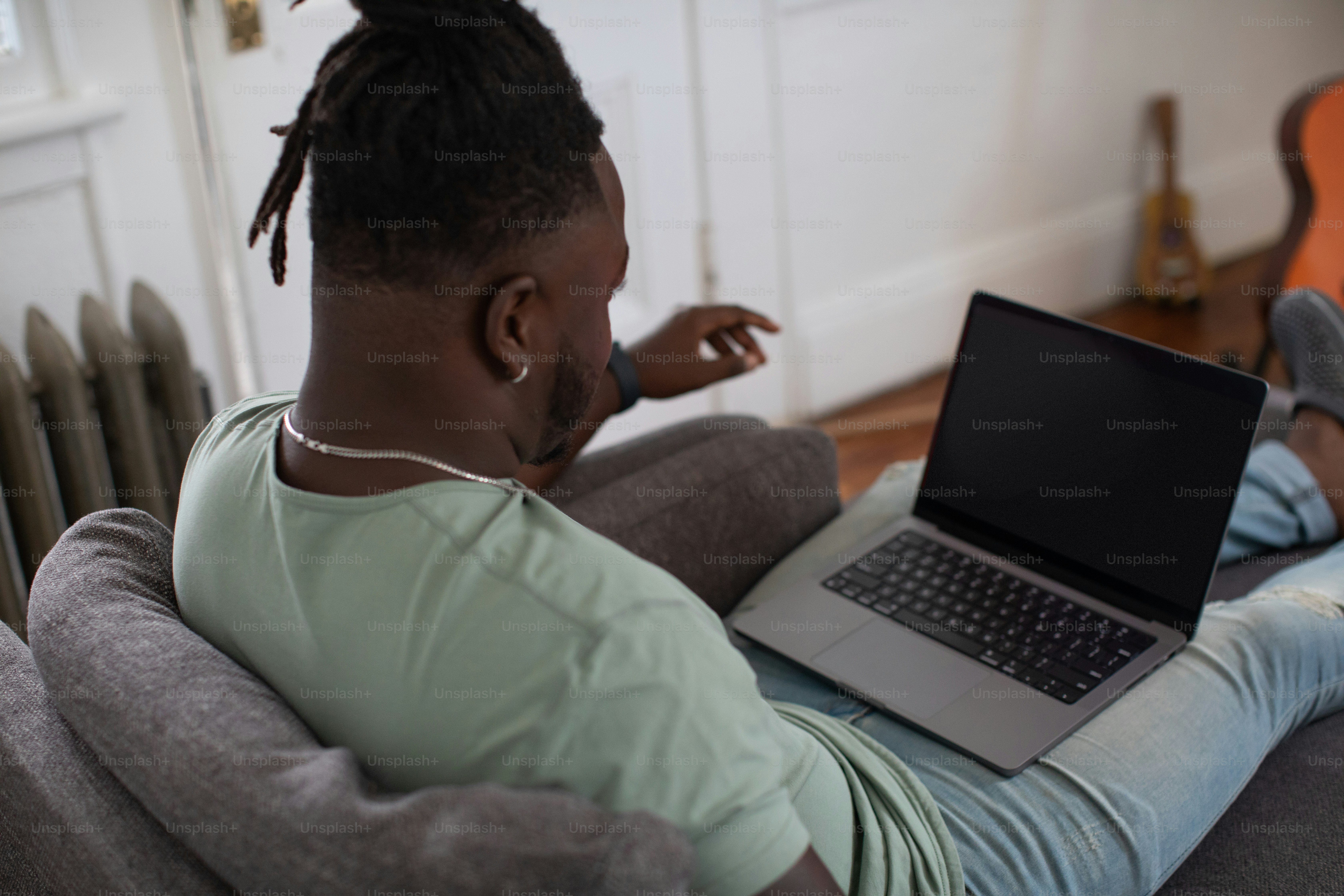 a man sitting on a couch using a laptop computer
