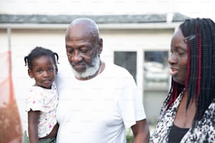 an older man and two young girls standing outside