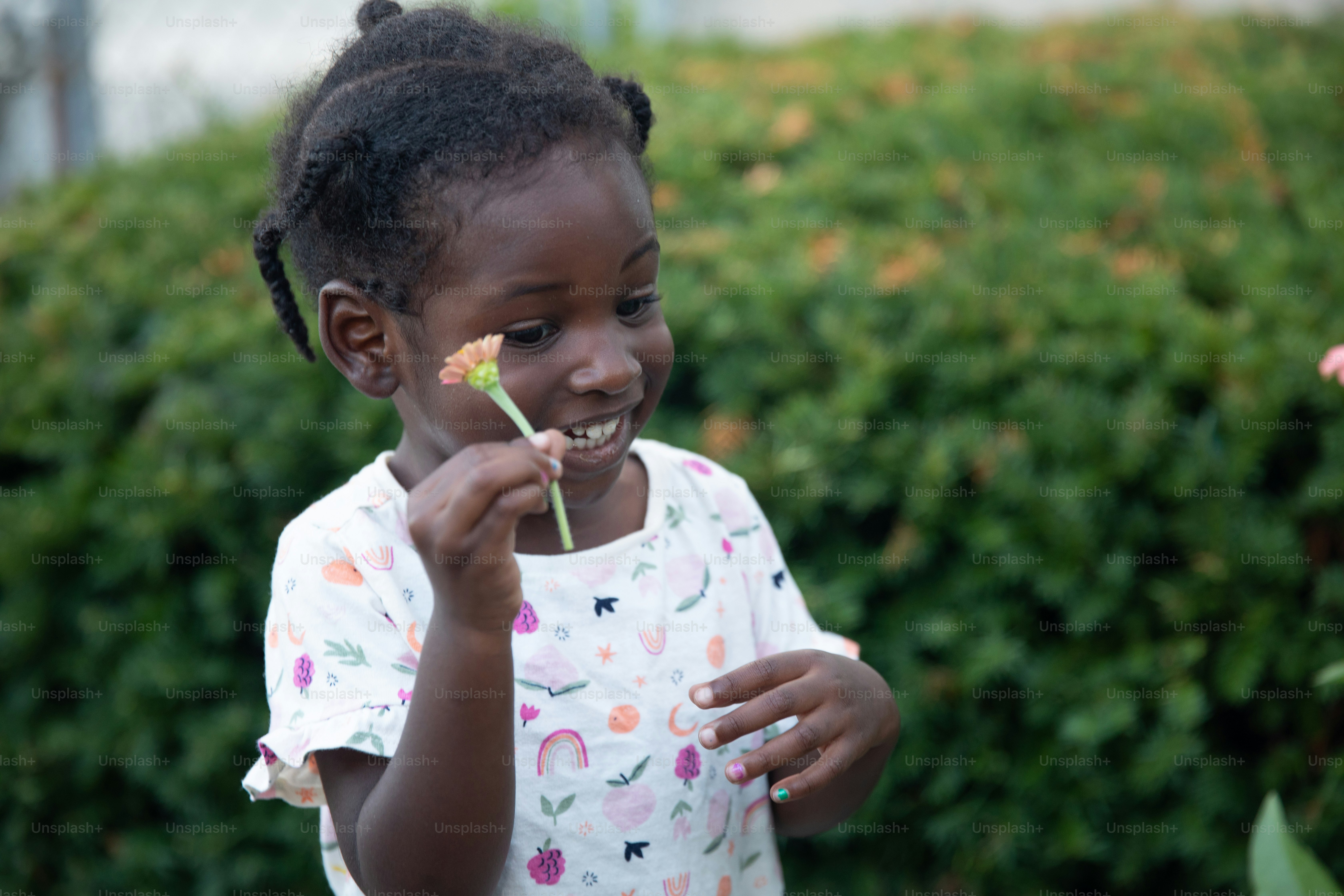 a little girl holding a flower in her mouth