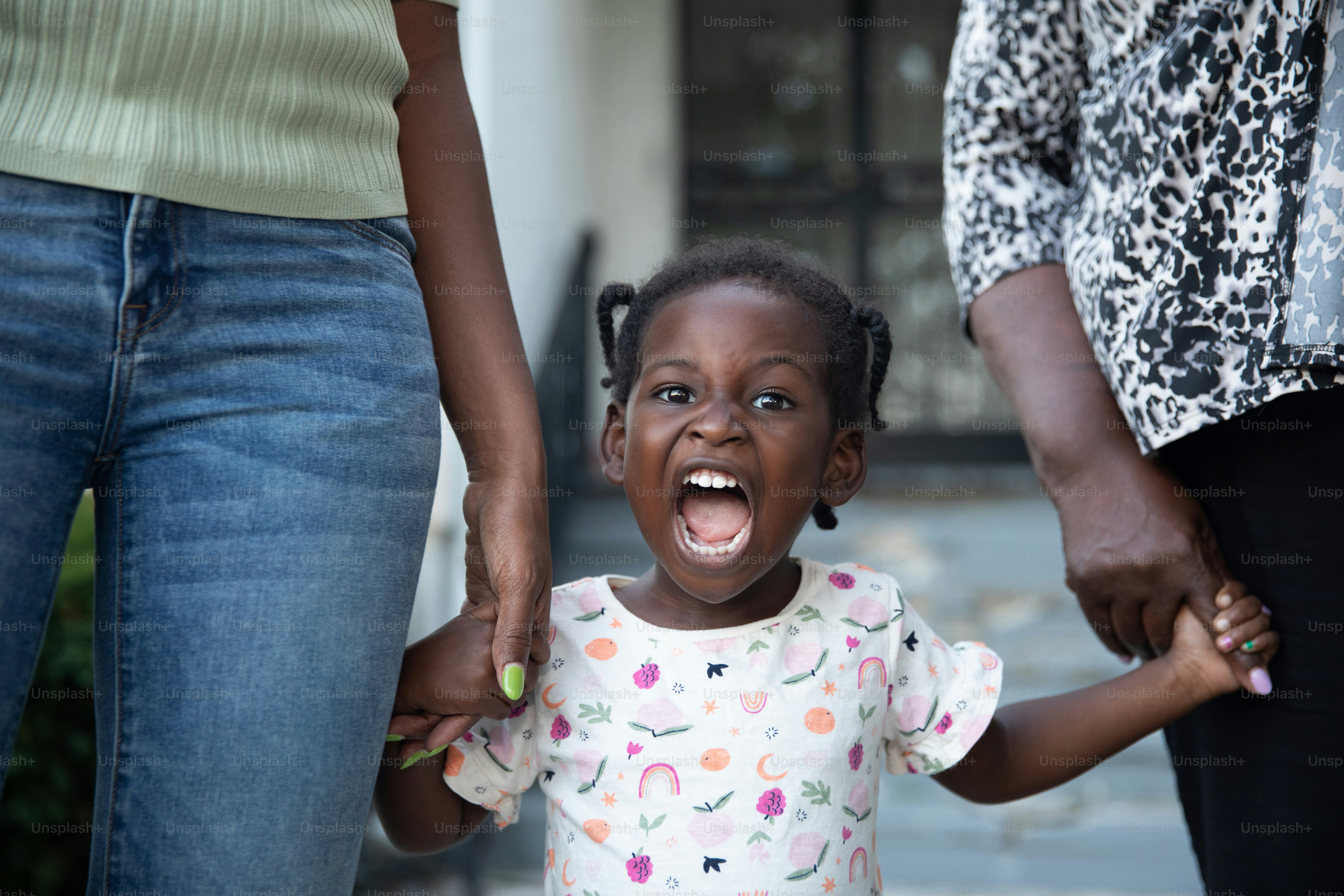 a little girl holding the hand of an adult