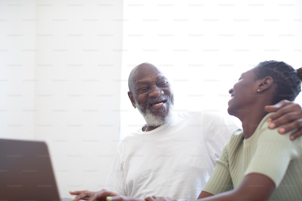 a man and a woman sitting in front of a laptop computer