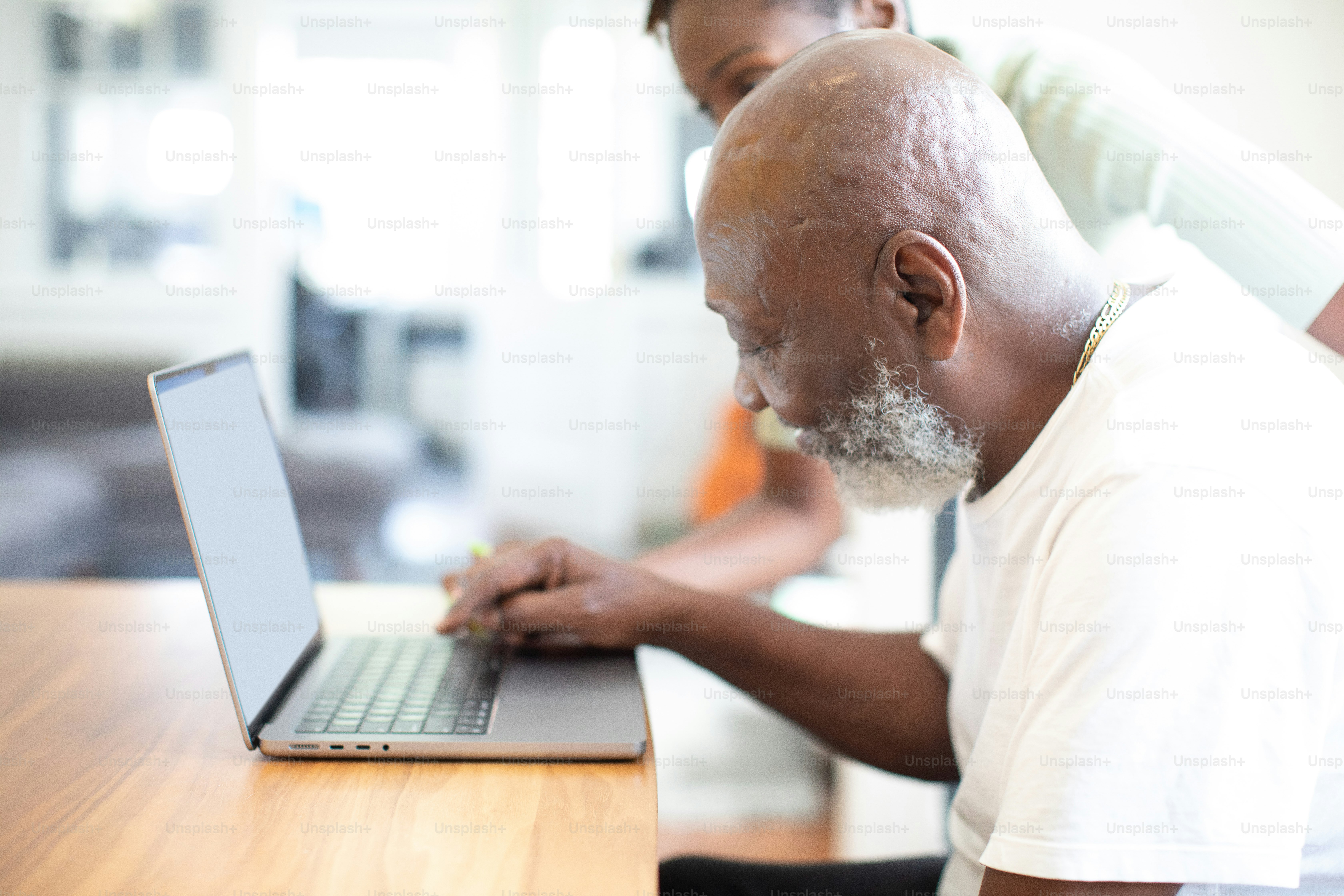 a man sitting at a table using a laptop computer