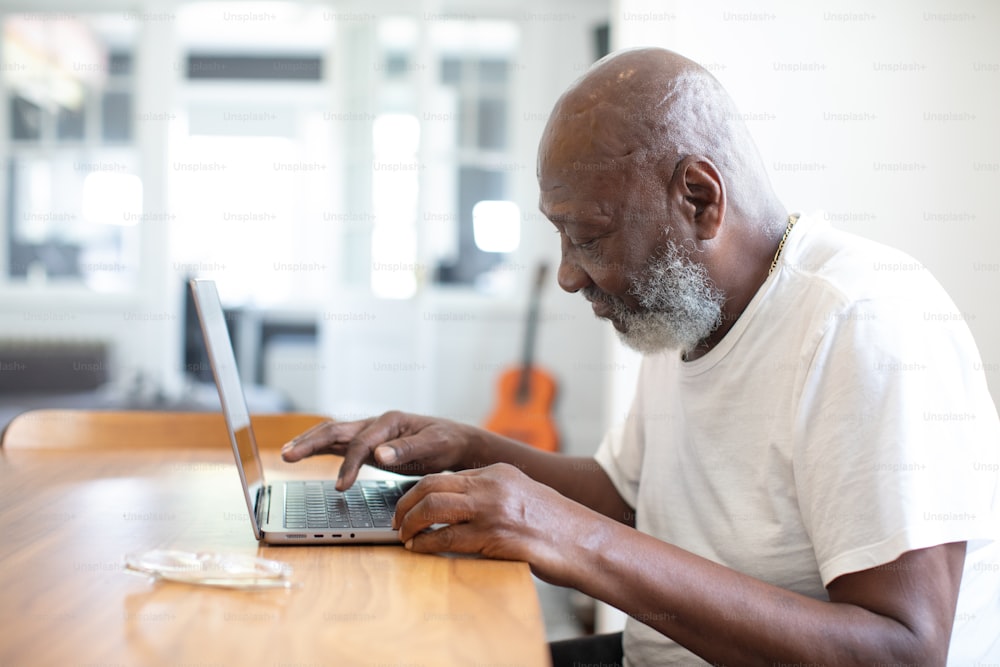 um homem sentado em uma mesa usando um computador portátil