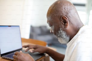 a man sitting at a table using a laptop computer