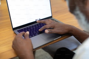 a man sitting at a table using a laptop computer