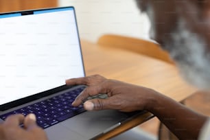 a man sitting at a table using a laptop computer