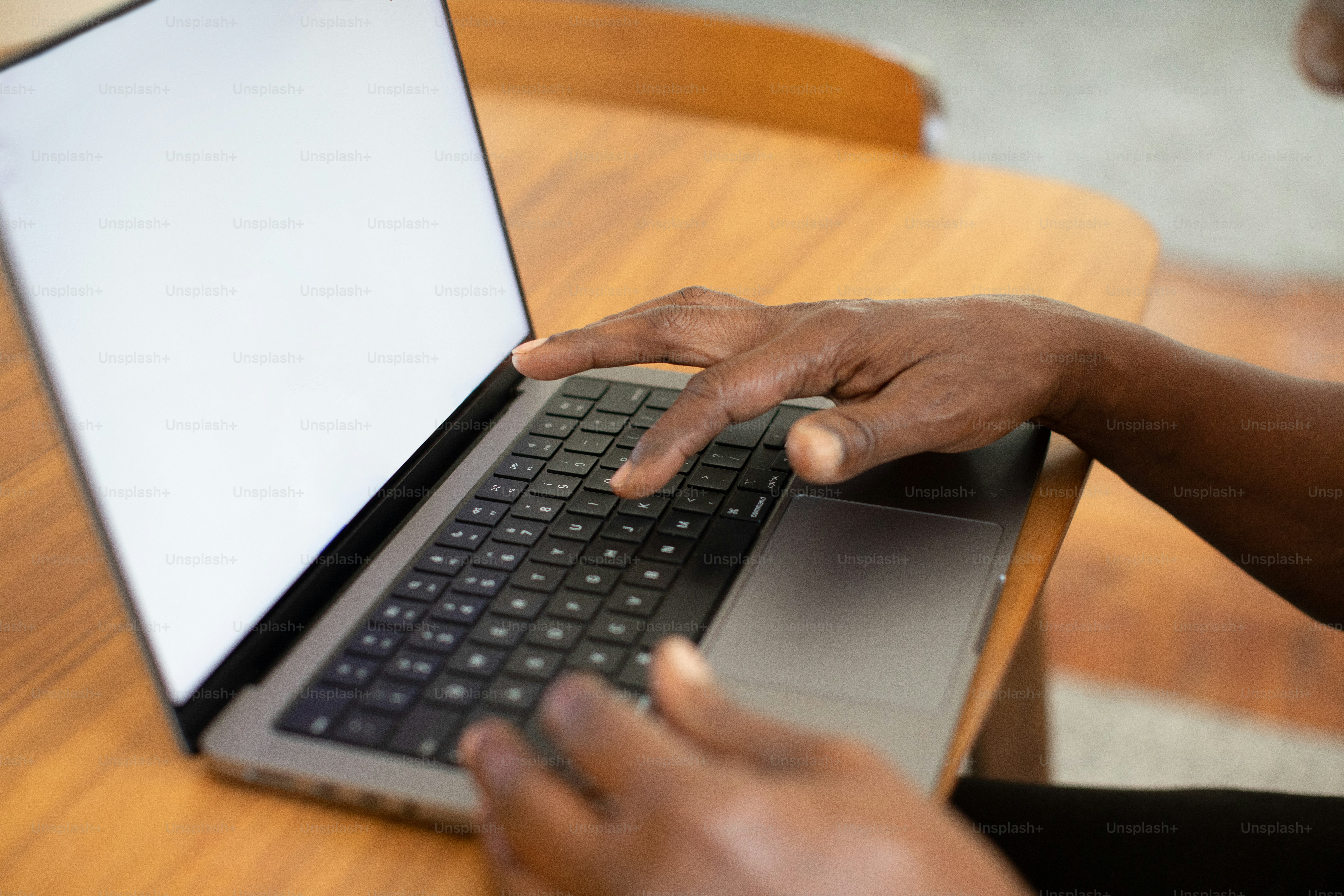 a person using a laptop on a wooden table