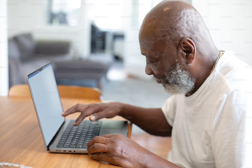 a man sitting at a table using a laptop computer