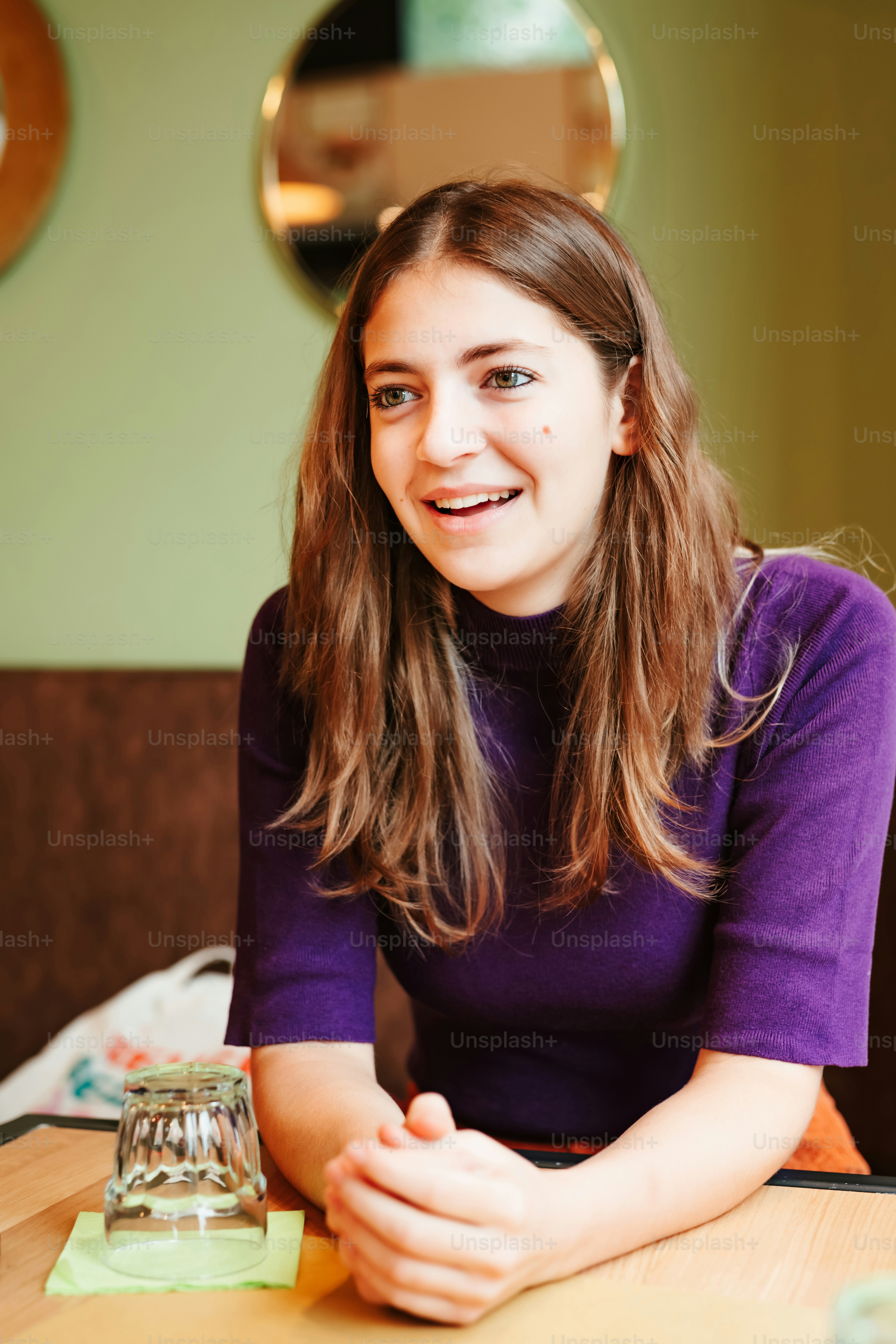 Una mujer sentada en una mesa sonriendo para la cámara