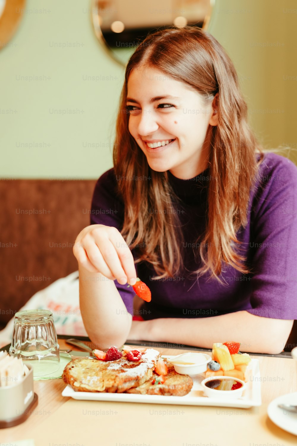 a woman sitting at a table with a plate of food