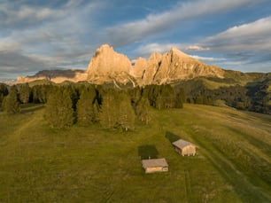 an aerial view of a mountain range with a small cabin in the foreground