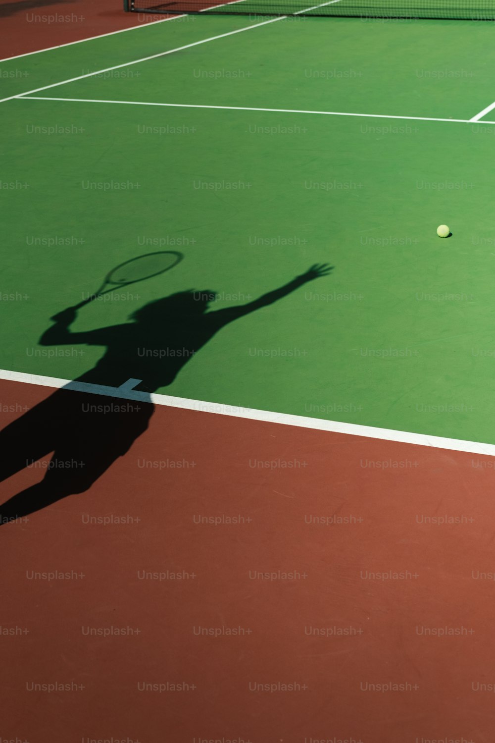 un'ombra di una persona su un campo da tennis