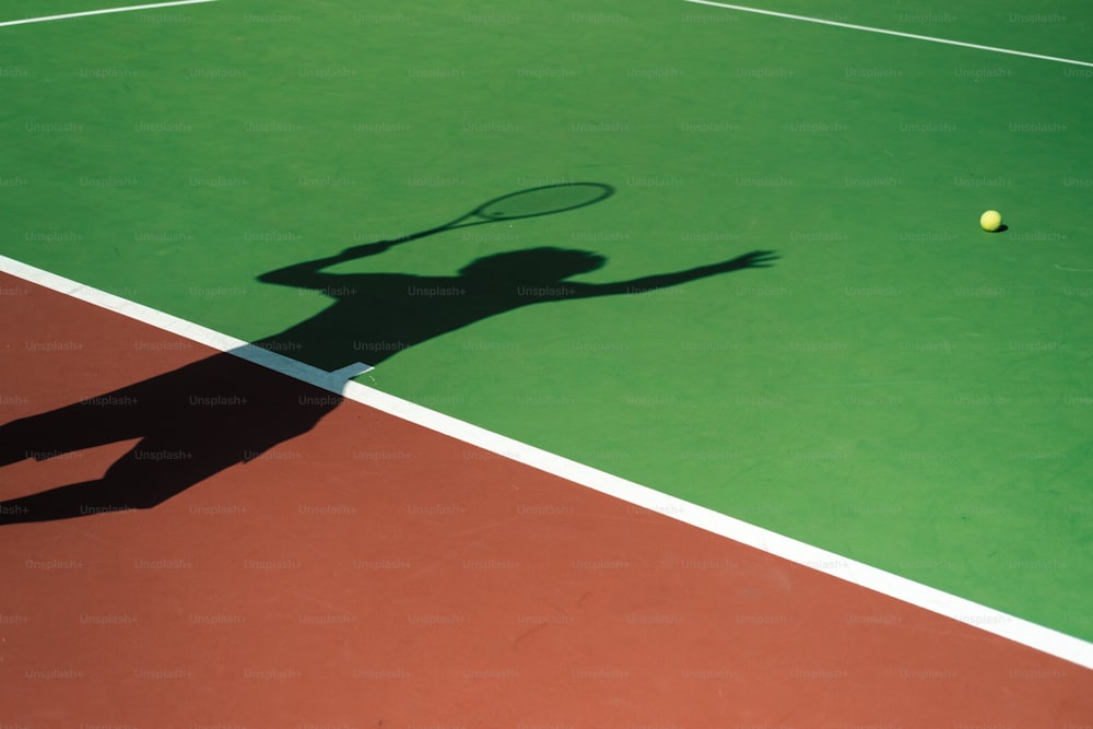 uma sombra de uma pessoa em uma quadra de tênis