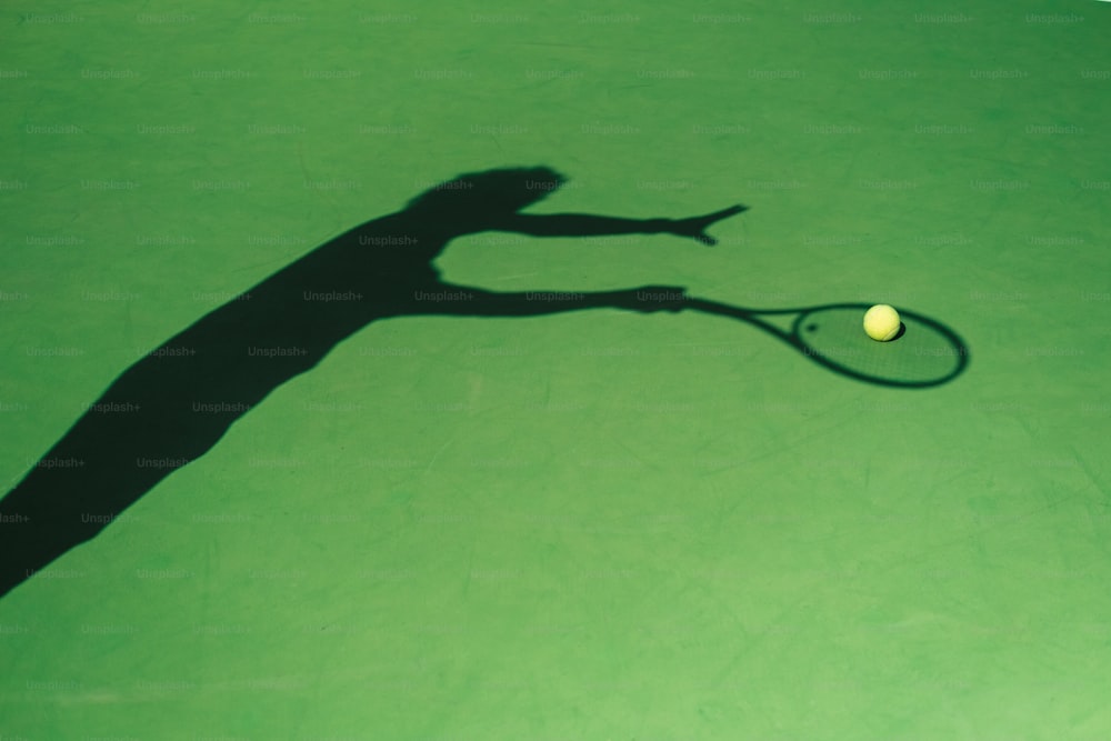 a shadow of a person holding a tennis racket