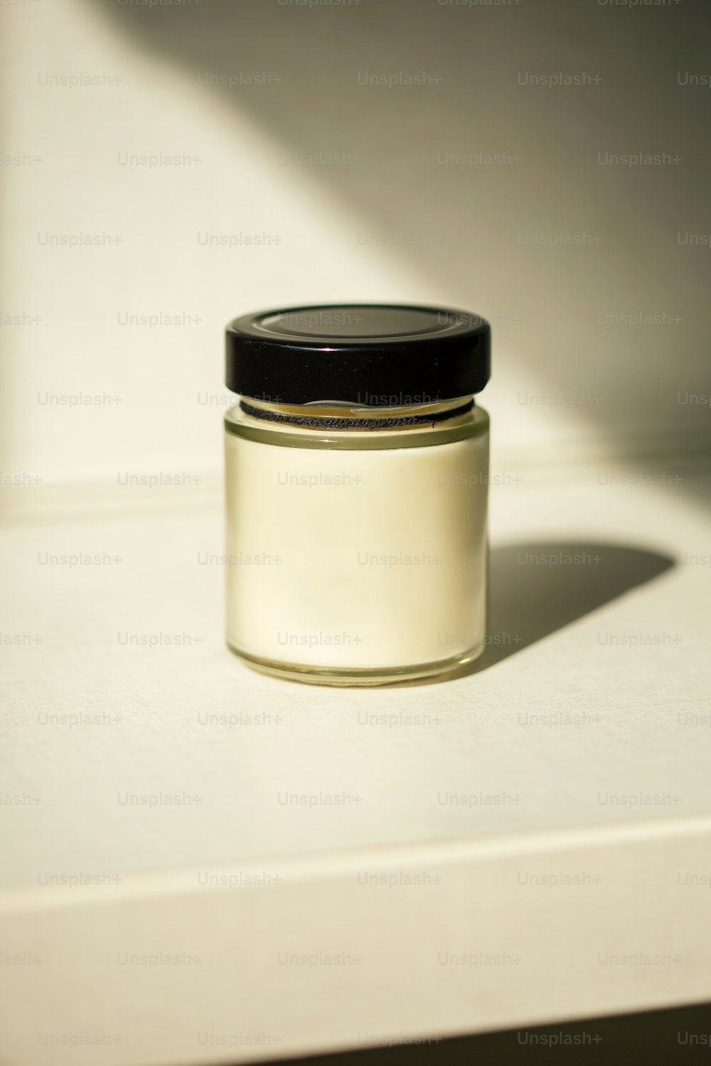a white jar with a black lid sitting on a counter