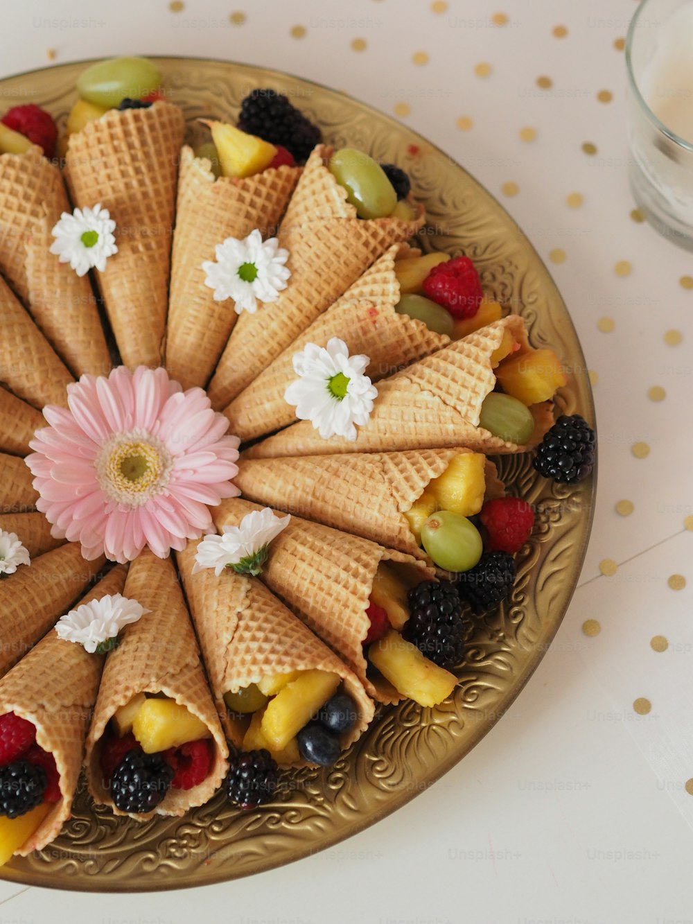 um prato de frutas e casquinhas de sorvete sobre uma mesa
