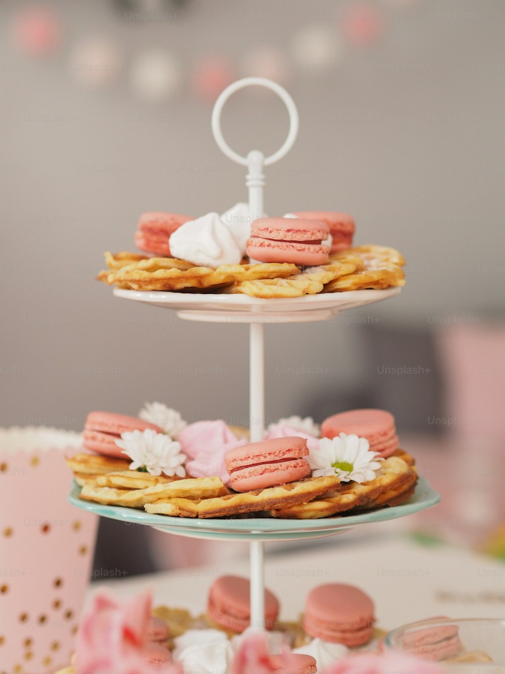a three tiered cake stand with macaroons on it
