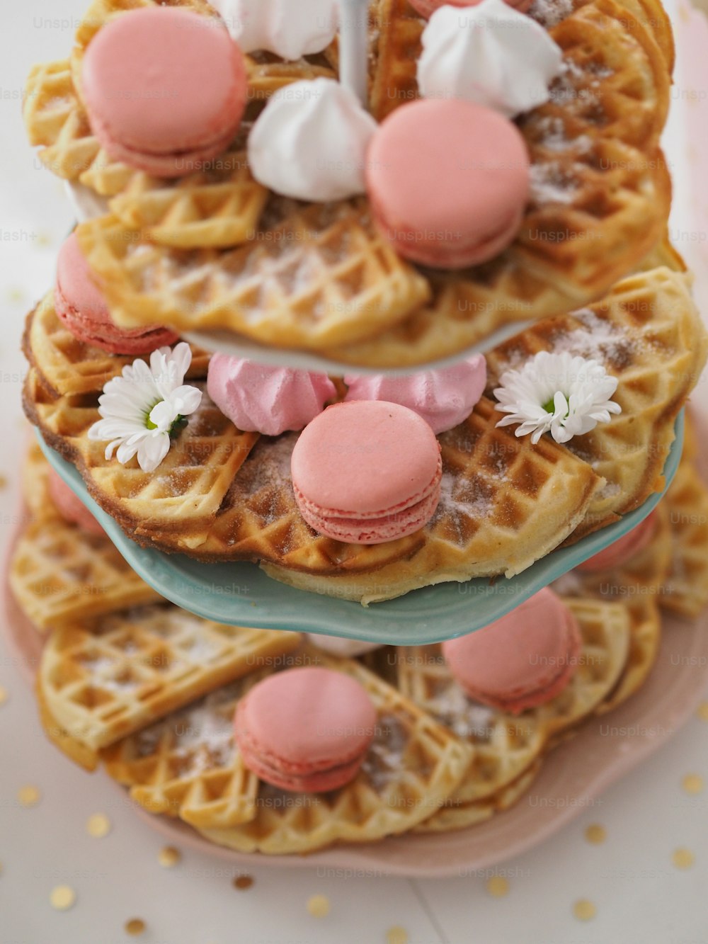 uma pilha de waffles cobertos com cobertura rosa e branca