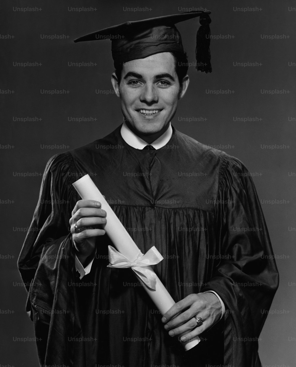 卒業式のガウンとモルタルボードを身にまとい、卒業証書を手にした青年、1960年頃。(写真提供:George Marks/Retrofile/Getty Images)