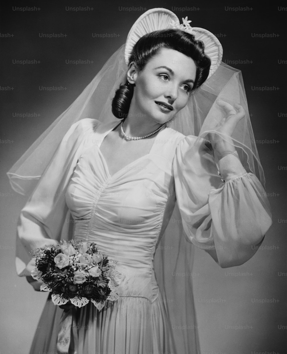 Una joven novia con velo y ramo, hacia 1940.  (Foto de George Marks/Retrofile/Getty Images)
