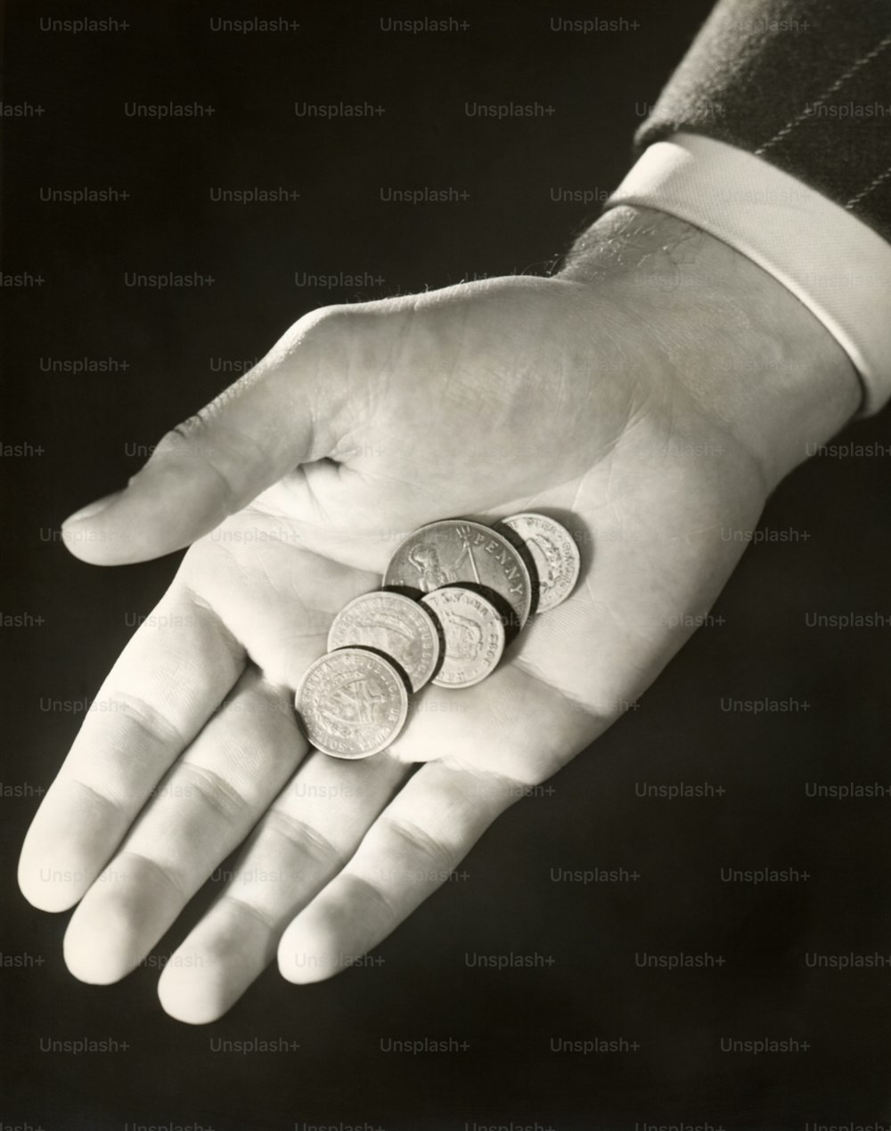 ESTADOS UNIDOS - CIRCA 1950s: Monedas en la mano del hombre.