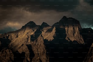a mountain range with a dark sky in the background