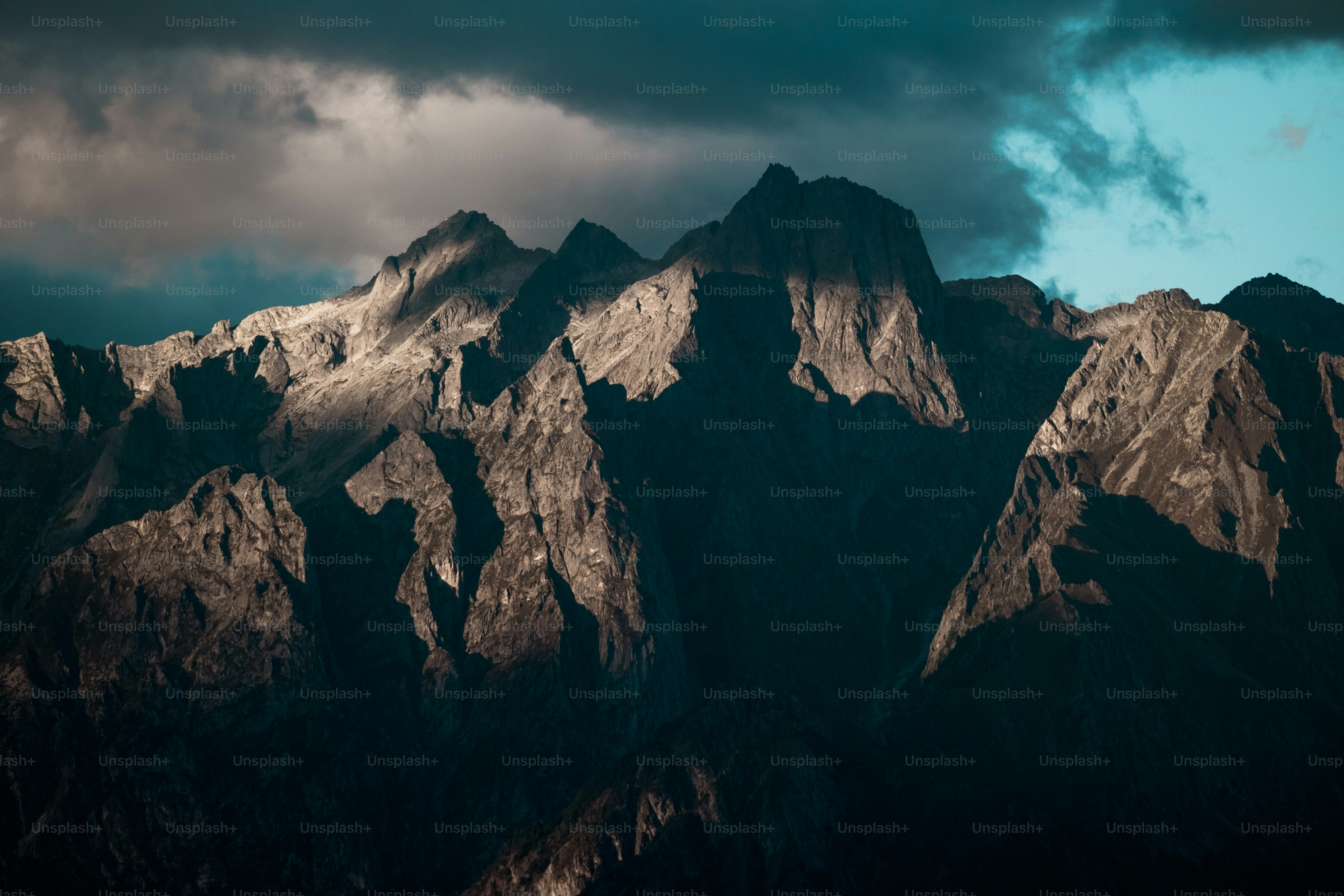 a very tall mountain with some clouds in the sky