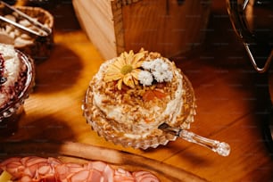 a wooden table topped with a cake covered in frosting