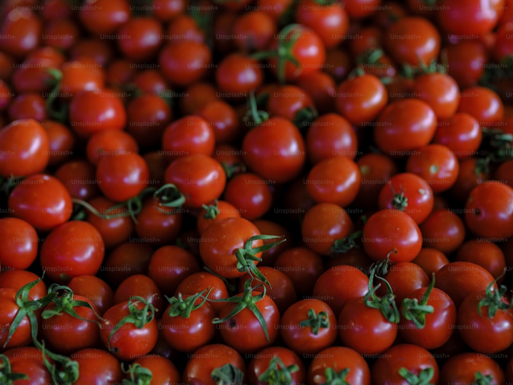 un tas de tomates avec des tiges vertes