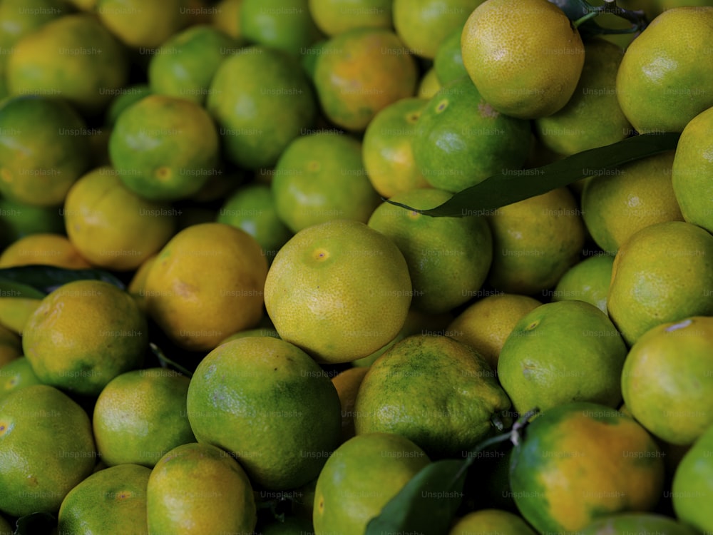 un montón de limones con hojas verdes en ellos
