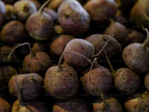 a pile of purple potatoes with dirt on them