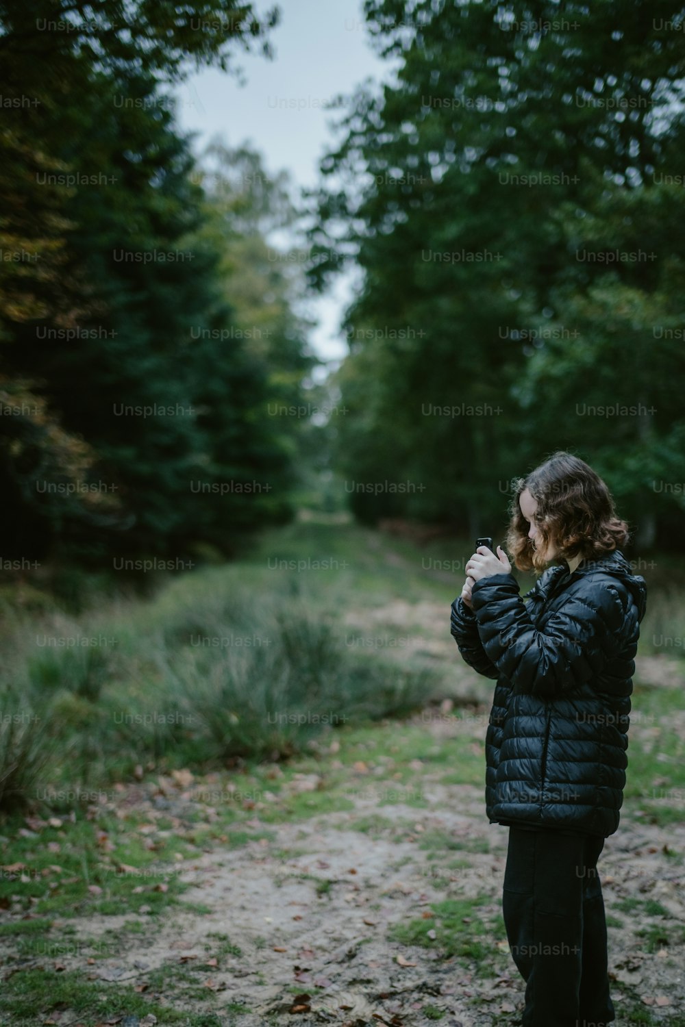 a woman in a black jacket is taking a picture