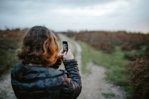 Una donna che scatta una foto di una strada sterrata