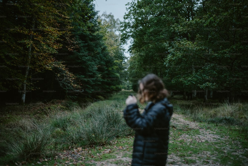 uma mulher em pé no meio de uma floresta