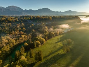 an aerial view of a valley with trees in the foreground and mountains in the