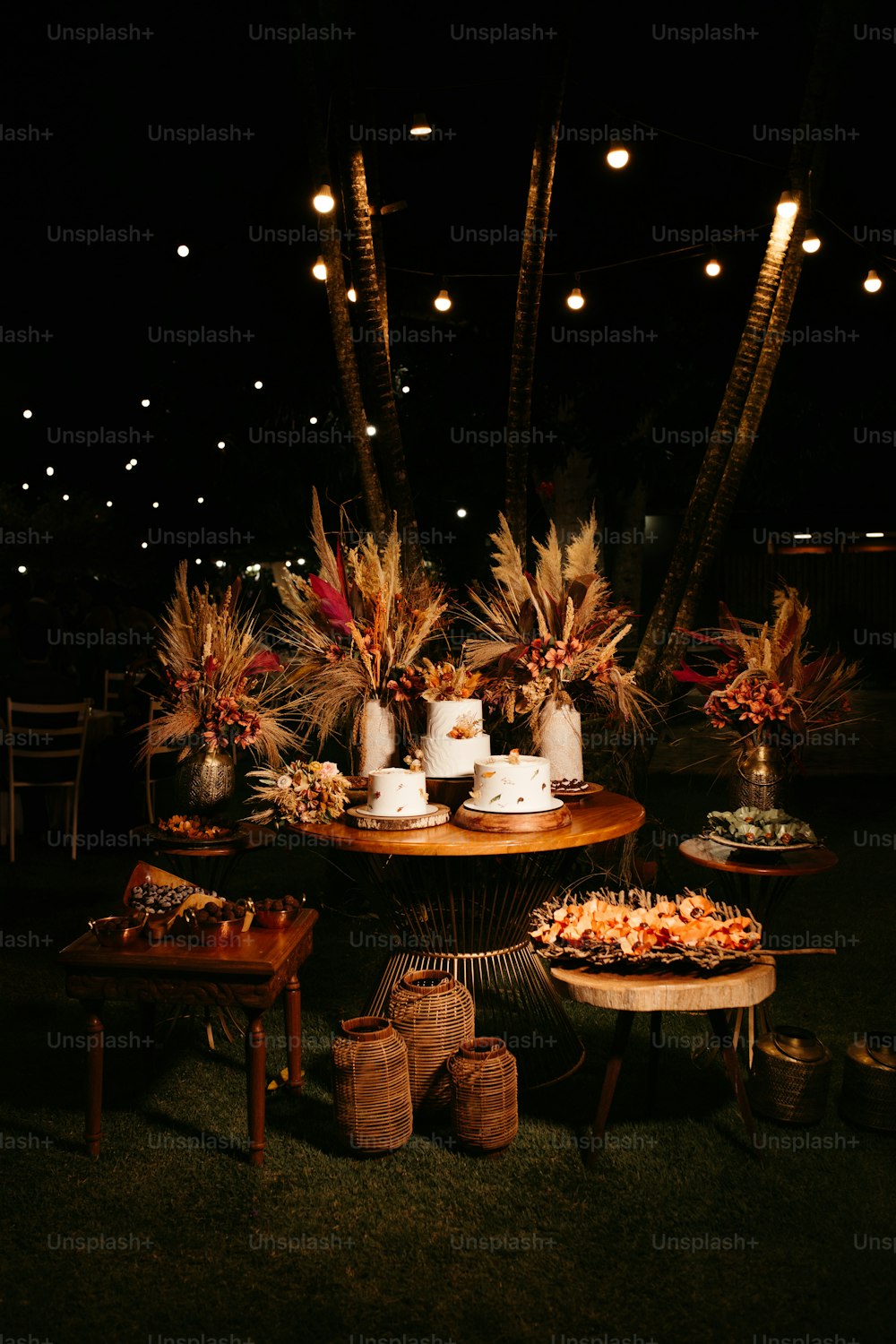 Una mesa cubierta con un pastel junto a palmeras