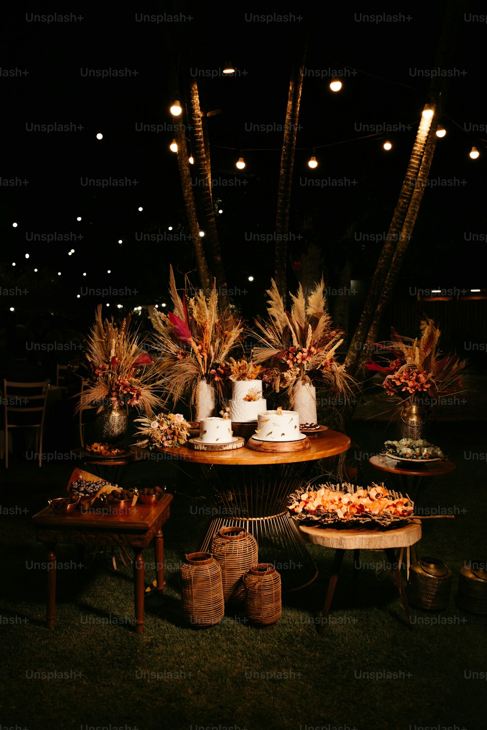 a table topped with a cake next to palm trees