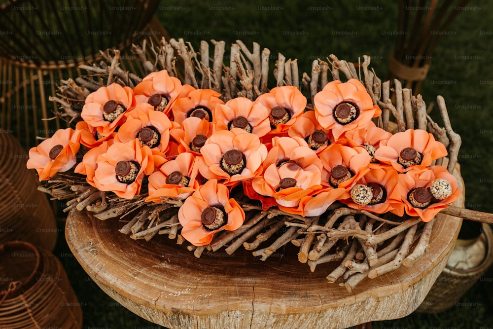 um ramo de flores alaranjadas sentado em cima de uma mesa de madeira