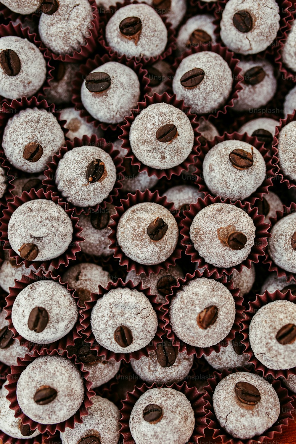 a close up of a tray of cupcakes covered in powdered sugar